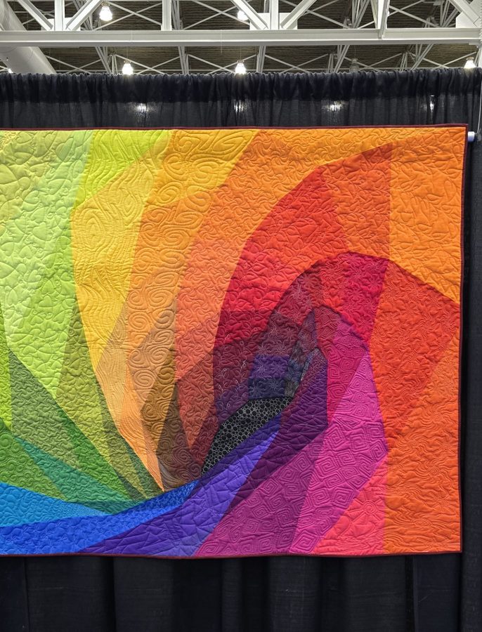 A quilt of angular colour facets sweeping through the full spectrum, from green and yellow into orange, red and purple