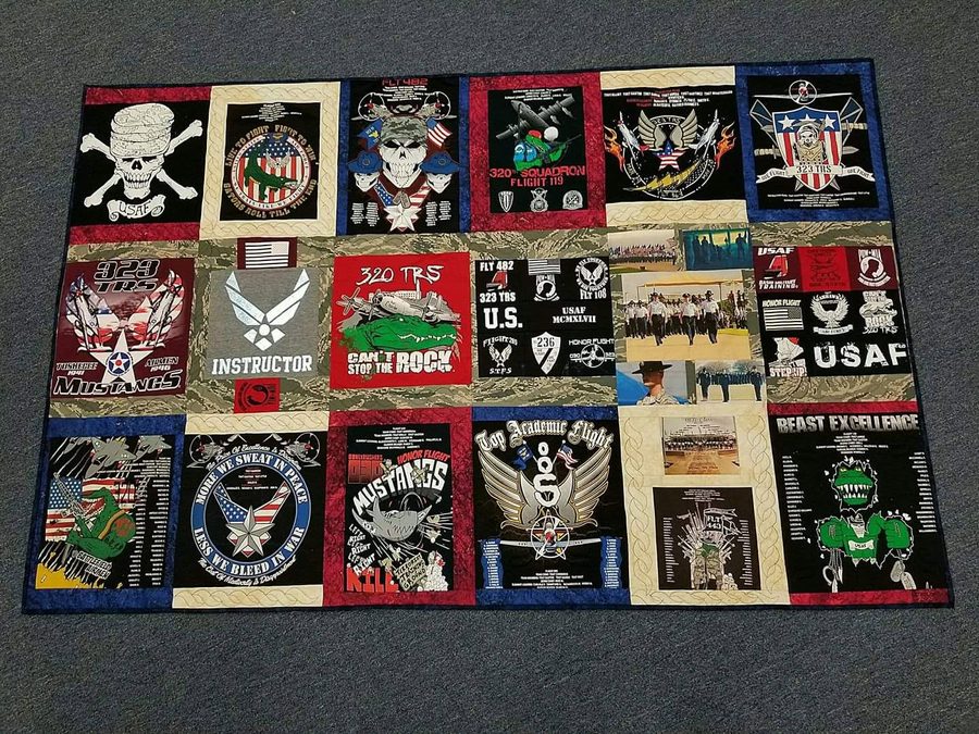 A memory quilt pieced from military unit shirts, squadron patches and insignia on a navy ground